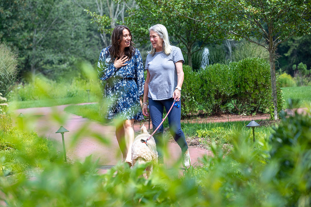 Senior woman walking her dog with her daughter